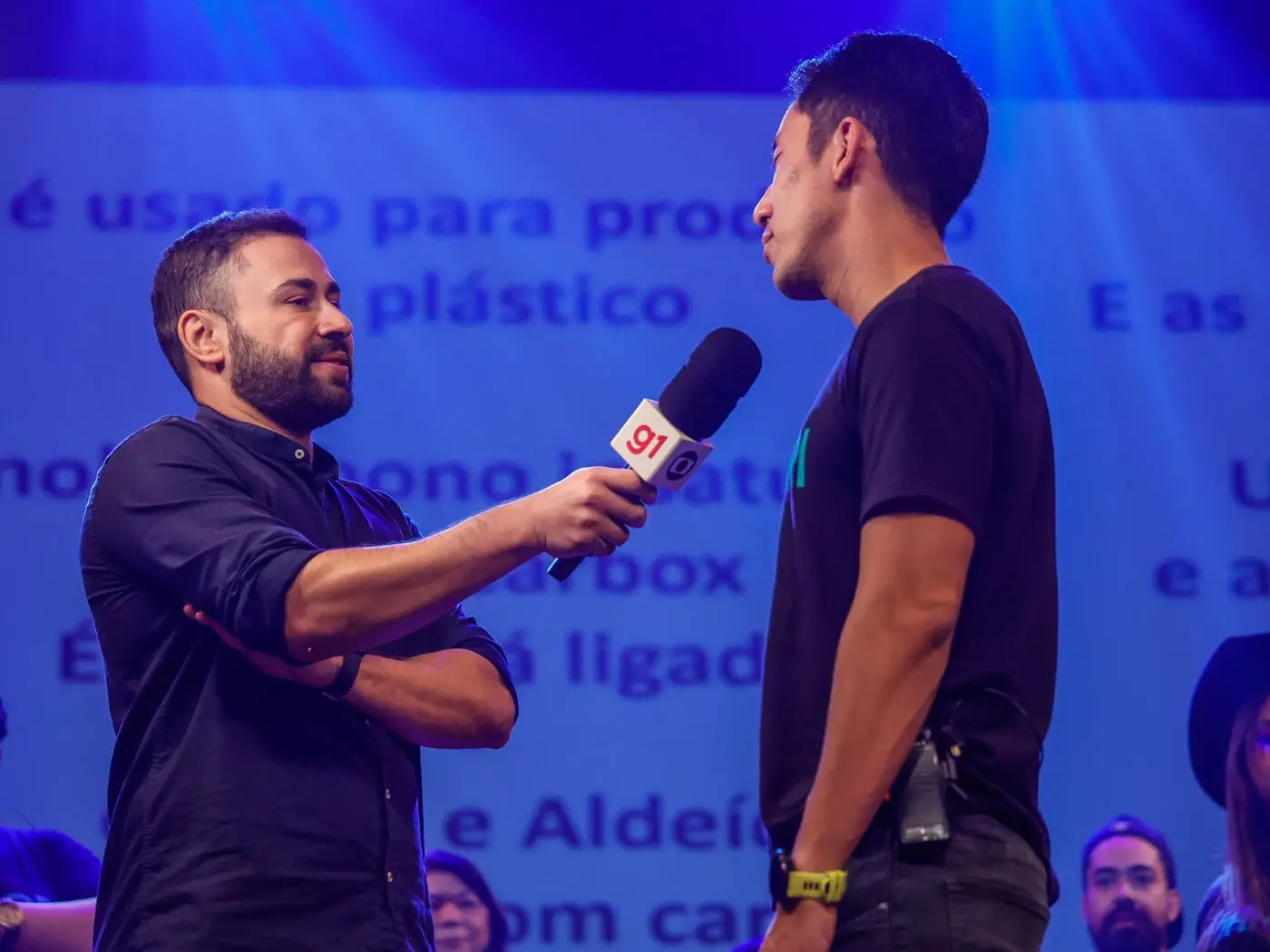 Repórter do g1 entrevistando um professor no palco